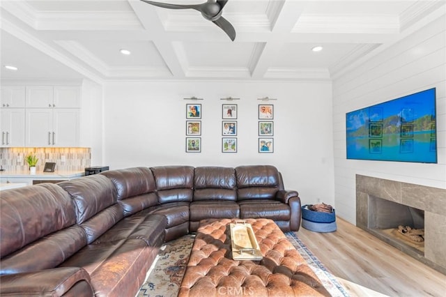 living area with coffered ceiling, a fireplace, and beamed ceiling