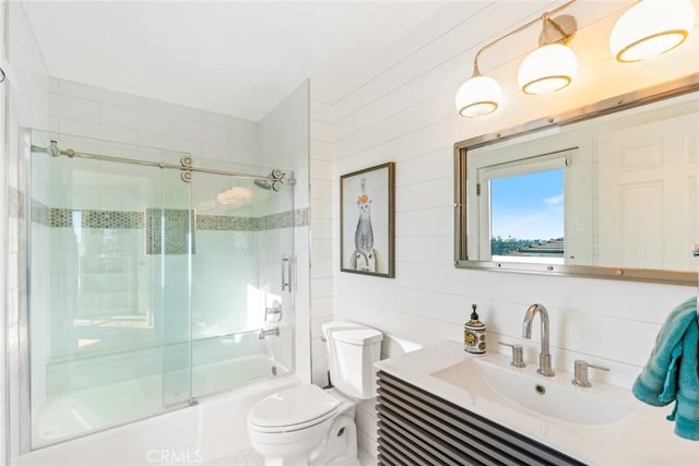 bathroom with combined bath / shower with glass door, vanity, and toilet