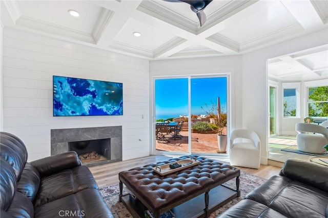 living room with beam ceiling, coffered ceiling, a fireplace, and wood finished floors