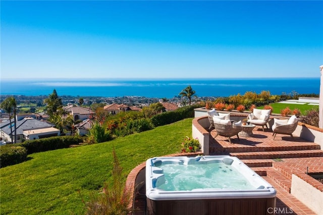 view of yard featuring a patio area, a water view, and a hot tub