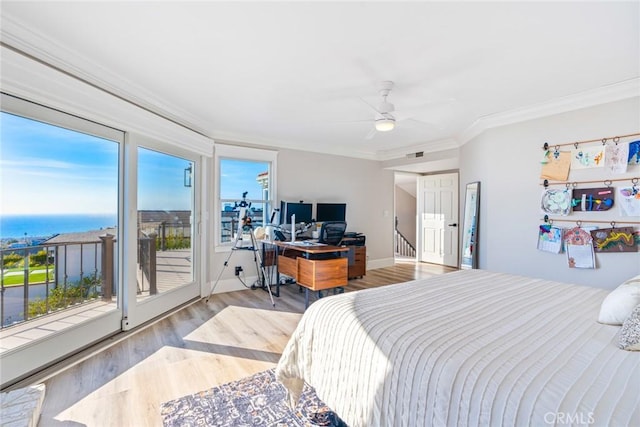 bedroom featuring a water view, baseboards, access to exterior, light wood finished floors, and crown molding