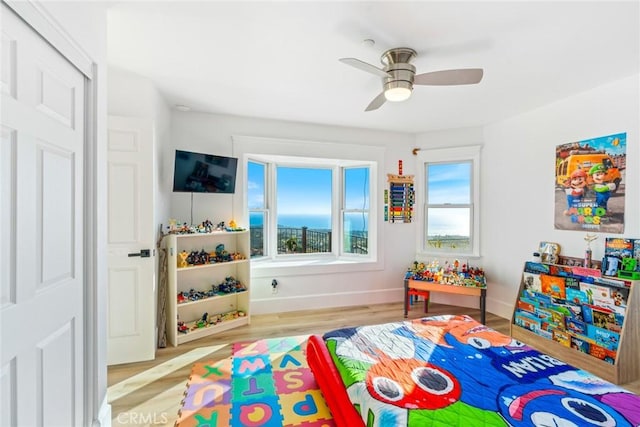 bedroom featuring light wood-type flooring, a ceiling fan, and baseboards