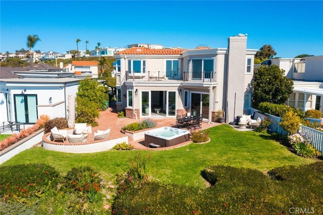 back of house featuring a patio, fence, a balcony, and a hot tub