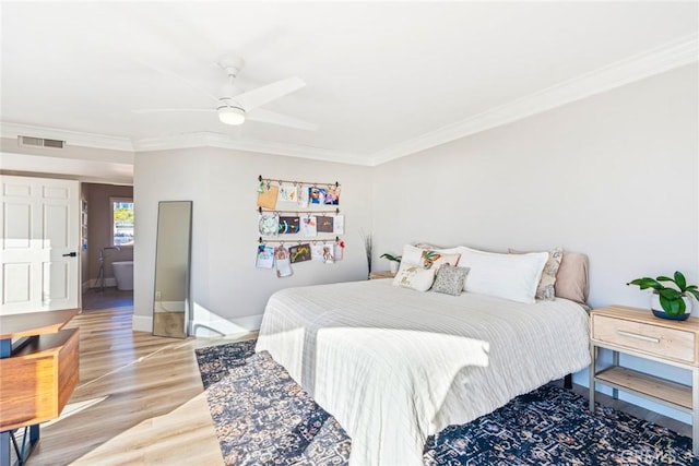 bedroom featuring visible vents, ornamental molding, light wood-style floors, a ceiling fan, and baseboards