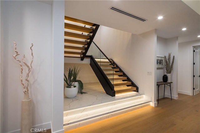 stairs with hardwood / wood-style flooring