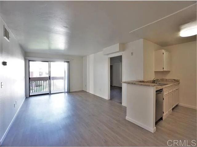 kitchen featuring white cabinetry, sink, stainless steel dishwasher, and light hardwood / wood-style floors