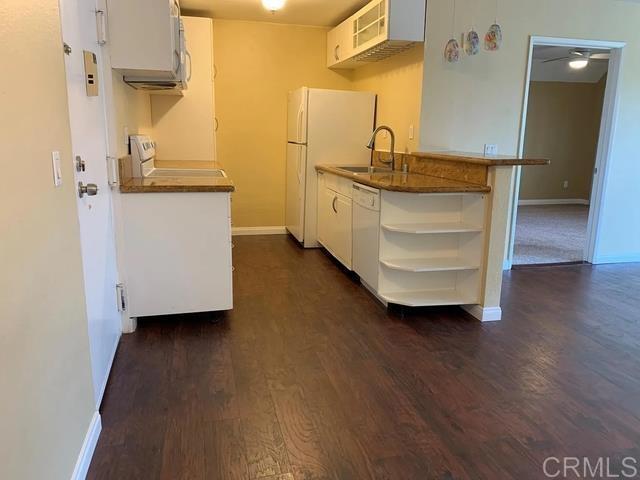 kitchen featuring dishwasher, sink, white cabinets, fridge, and range