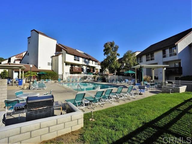 view of pool with an outdoor kitchen, a lawn, and a patio area