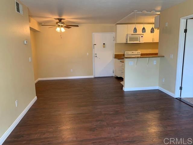 kitchen with white cabinetry, hanging light fixtures, dark hardwood / wood-style floors, kitchen peninsula, and ceiling fan