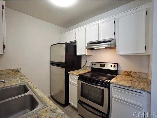 kitchen featuring light stone countertops, white cabinetry, appliances with stainless steel finishes, and sink