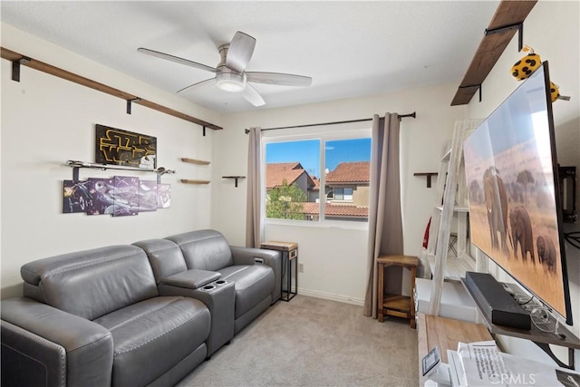 carpeted living area featuring ceiling fan and baseboards