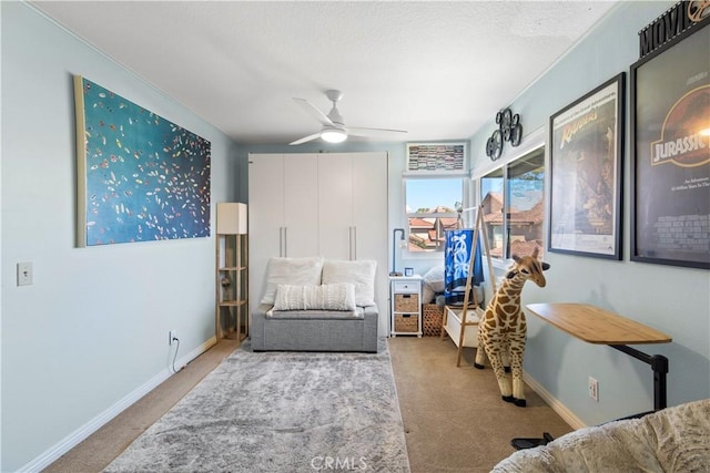 living area with carpet floors, baseboards, and a ceiling fan