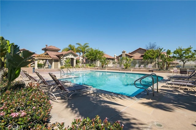 pool with a patio area and fence