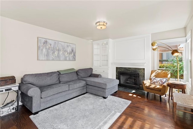 living area featuring dark wood-type flooring and a high end fireplace