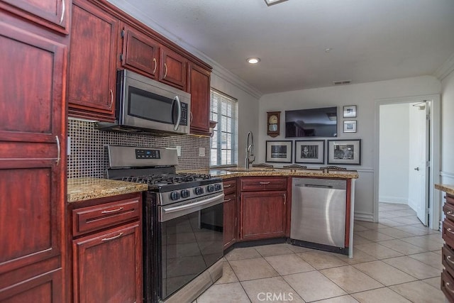 kitchen featuring stainless steel appliances, dark brown cabinets, a sink, and visible vents