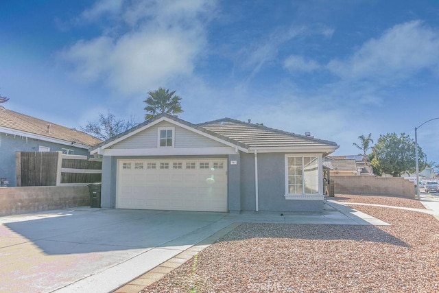 ranch-style home with a tile roof, stucco siding, concrete driveway, fence, and a garage