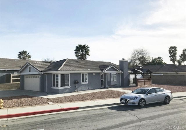 single story home featuring a tile roof, a garage, driveway, and stucco siding