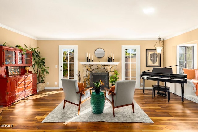 sitting room featuring ornamental molding, a fireplace, wood finished floors, and baseboards