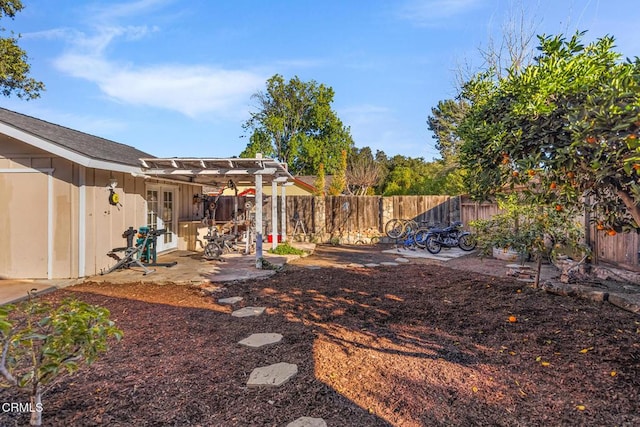 view of yard featuring a patio, french doors, a fenced backyard, and a pergola