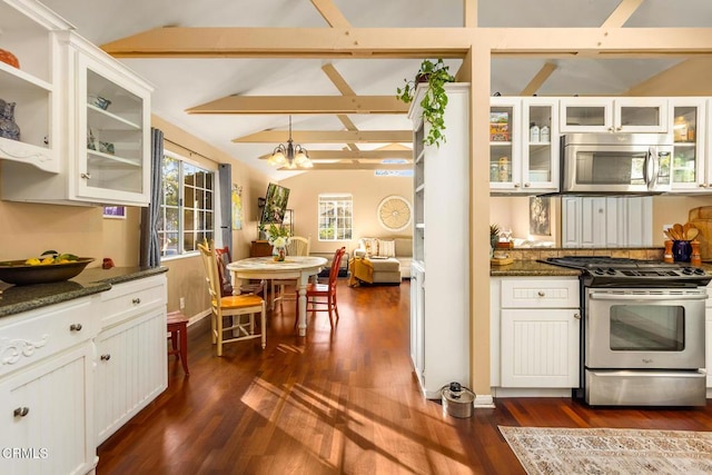 kitchen with vaulted ceiling with beams, appliances with stainless steel finishes, dark wood-style floors, and a notable chandelier