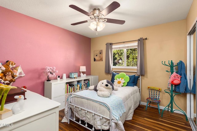 bedroom with a ceiling fan, baseboards, and wood finished floors