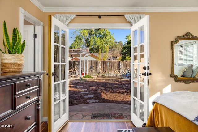 entryway featuring french doors, crown molding, and wood finished floors