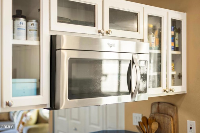 interior details with stainless steel microwave and glass insert cabinets