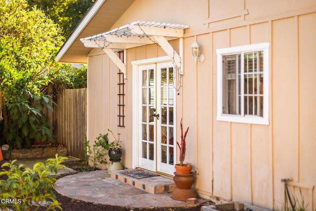 view of outdoor structure featuring french doors and fence