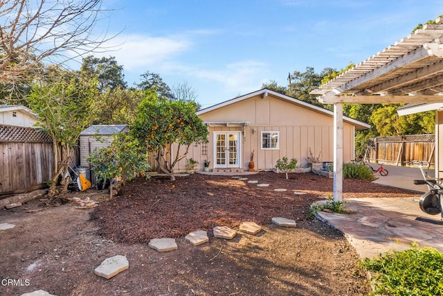 rear view of property with french doors, a fenced backyard, a patio, and an outdoor structure