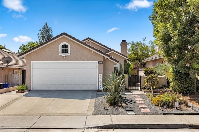 view of front of property featuring a garage, concrete driveway, a chimney, a gate, and stucco siding