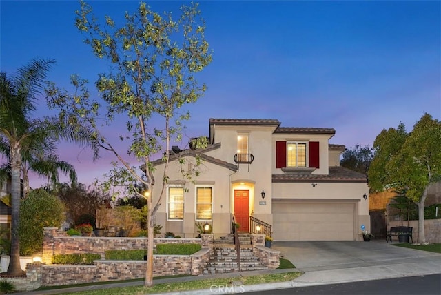 mediterranean / spanish home with concrete driveway, a garage, and stucco siding