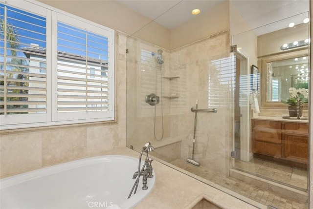 bathroom featuring a stall shower, vanity, and a bath