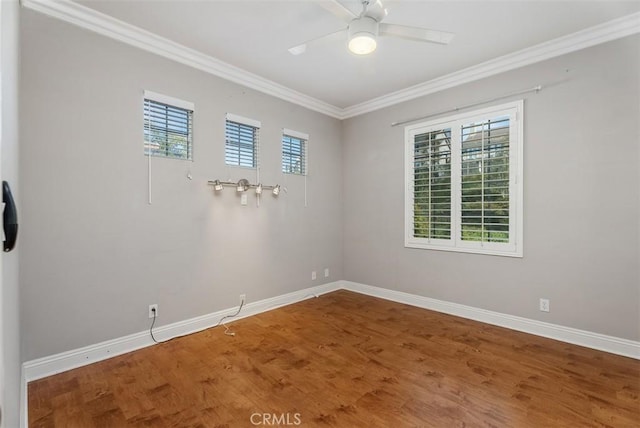 spare room featuring ceiling fan, baseboards, ornamental molding, and wood finished floors