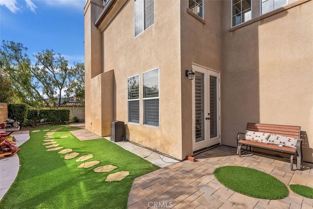 view of yard with french doors, fence, and a patio area