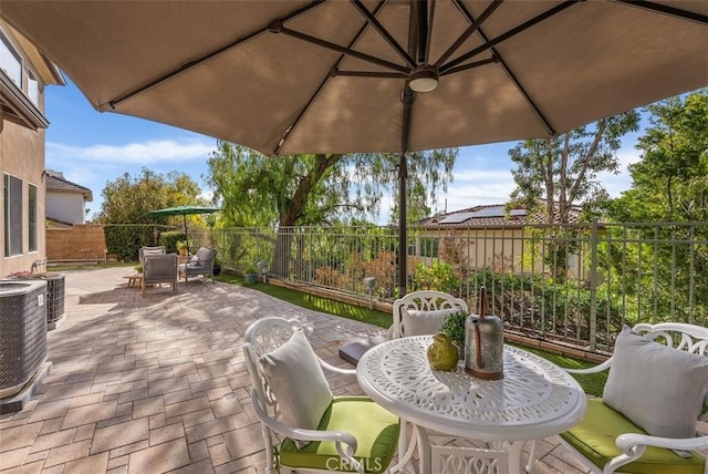 view of patio / terrace with outdoor dining area, central air condition unit, and a fenced backyard