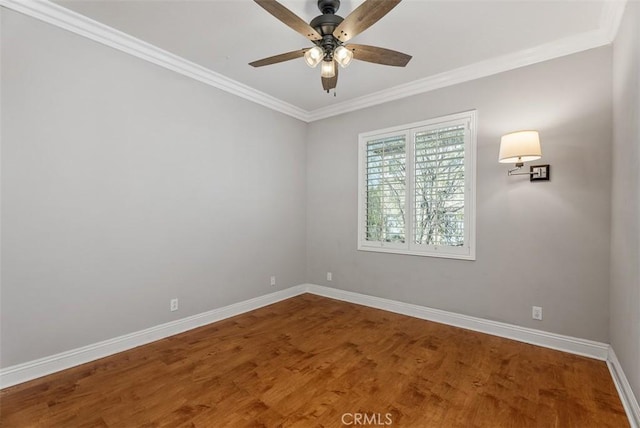 empty room with ceiling fan, crown molding, baseboards, and wood finished floors