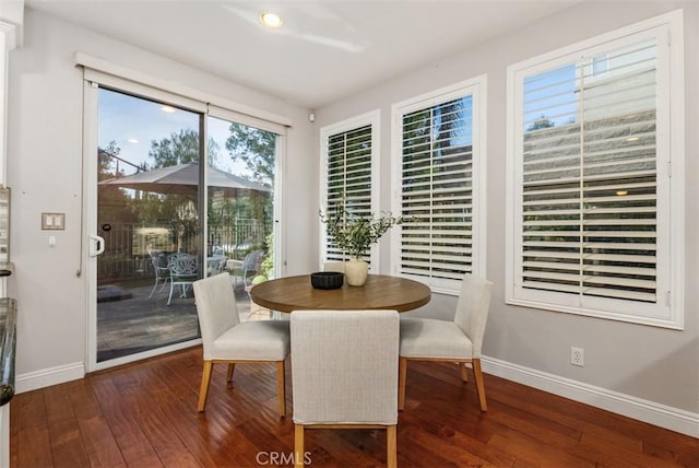 dining space with baseboards and dark wood-style flooring