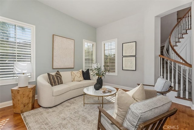 living area with stairs, baseboards, and wood finished floors