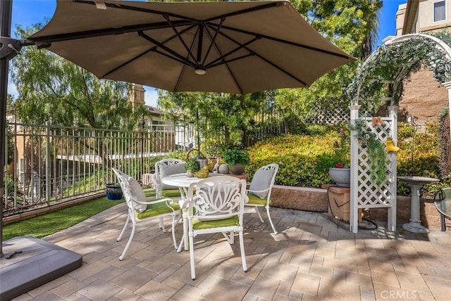 view of patio with outdoor dining area and fence