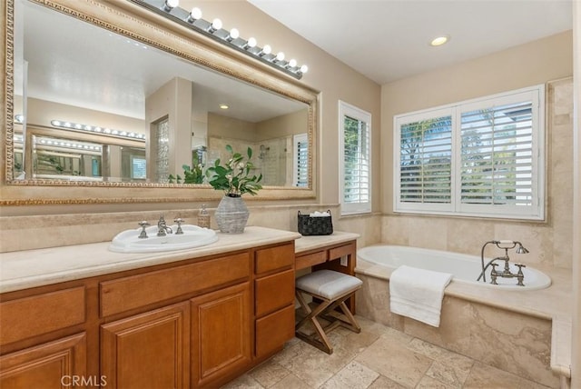 bathroom with vanity, a garden tub, plenty of natural light, and a stall shower