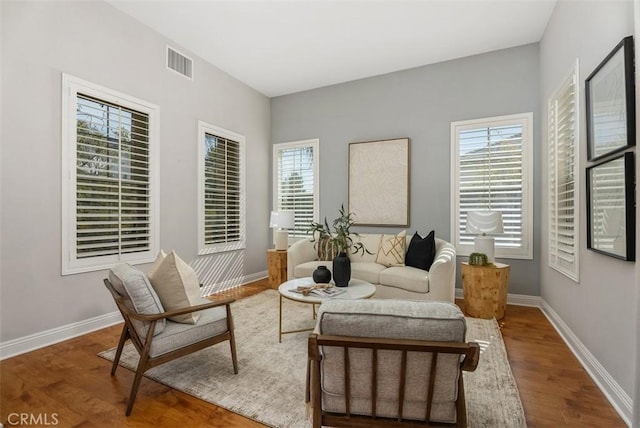 sitting room with visible vents, baseboards, and wood finished floors