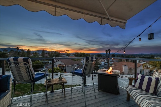 balcony at dusk featuring an outdoor fire pit and a mountain view