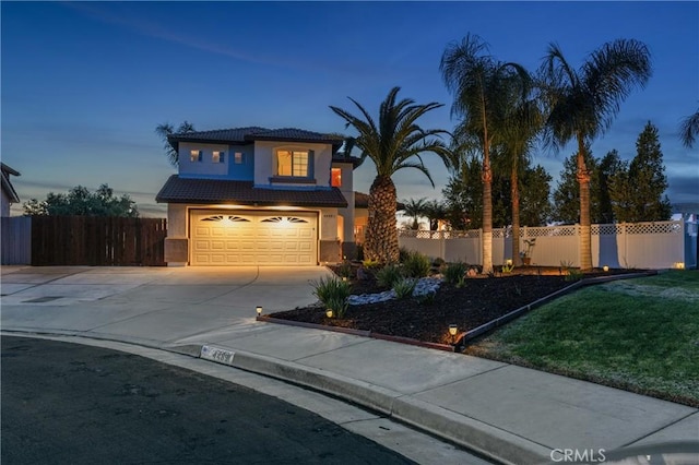 view of front facade featuring a fenced front yard, a garage, a tile roof, driveway, and stucco siding