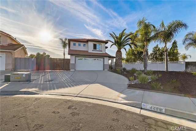 view of front facade with a garage, fence, concrete driveway, a tiled roof, and stucco siding