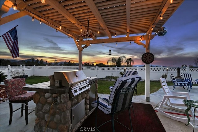 view of patio featuring exterior bar, area for grilling, a pergola, exterior kitchen, and a fenced backyard