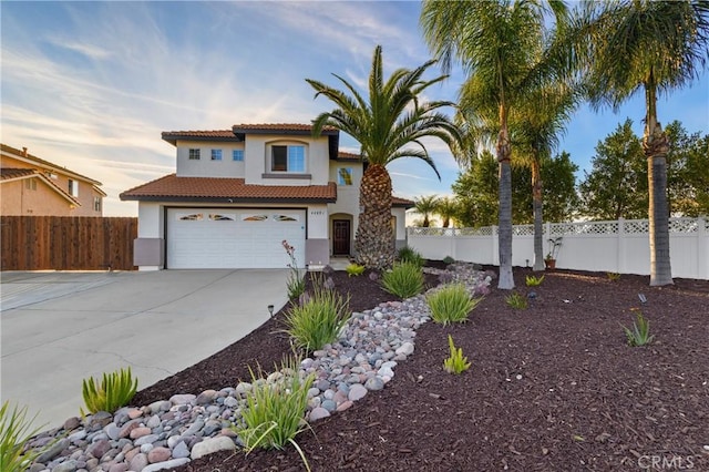 view of front of property with fence, driveway, an attached garage, and stucco siding