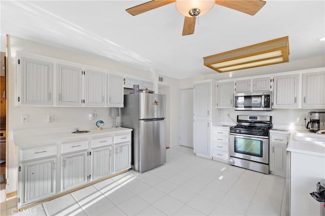 kitchen with light countertops, appliances with stainless steel finishes, light tile patterned flooring, and white cabinets