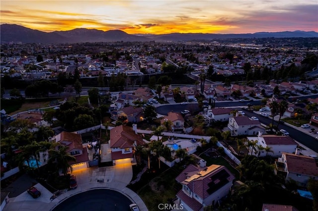 aerial view at dusk featuring a residential view and a mountain view