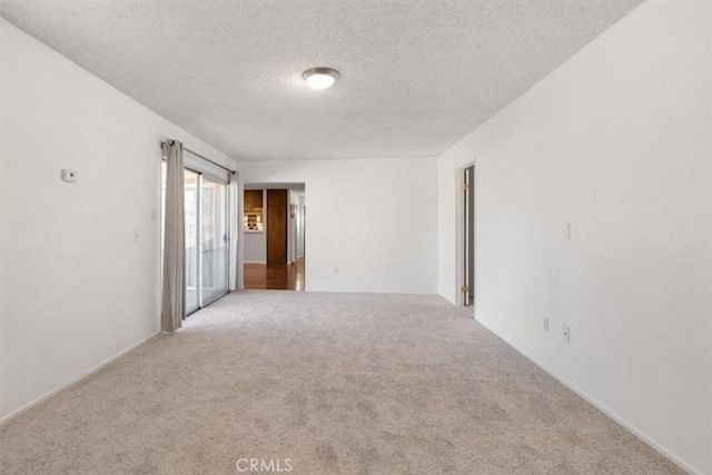 carpeted empty room with a textured ceiling