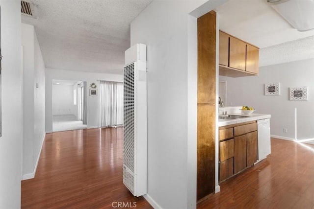 hallway with dark hardwood / wood-style flooring, sink, and a textured ceiling